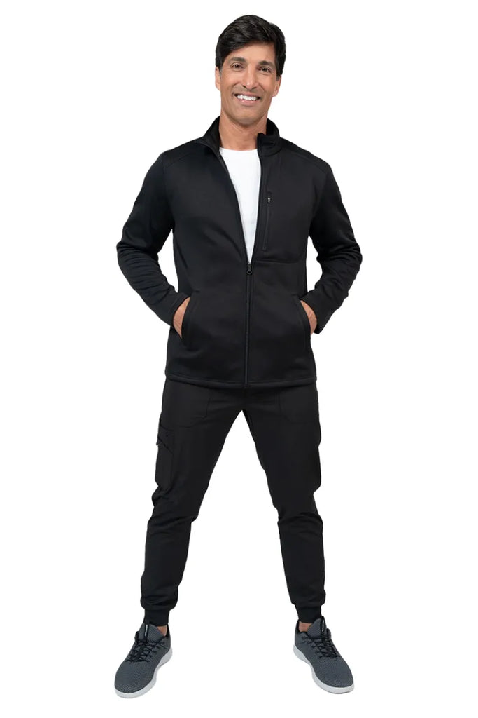 A full body image of a male nursing assistant wearing a Brandon Men's Bonded Fleece Jacket from Ava Therese in Black size XS featuring a full-zip front makes for easy on & off removal.