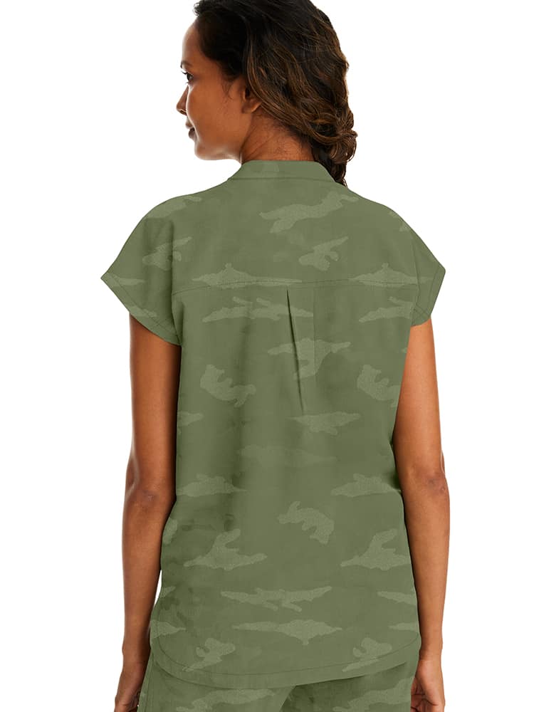 A young female Occupational Therapy Aide wearing a Purple Label Women's Journey Camo Top in Olive size Large featuring a center back length of 26.5".