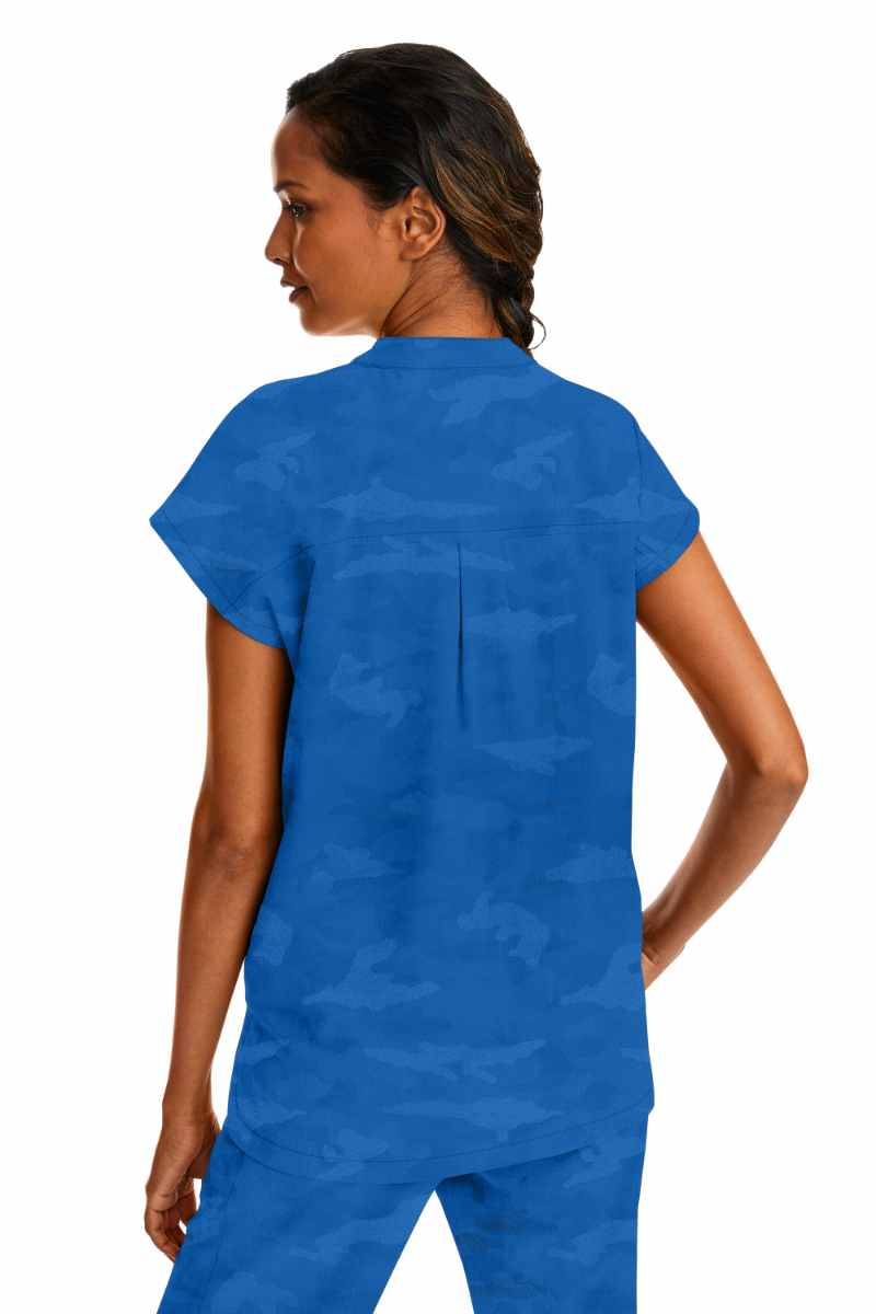 A young female Occupational Therapy Aide wearing a Purple Label Women's Journey Camo Top in Royal size Large featuring a center back length of 26.5".