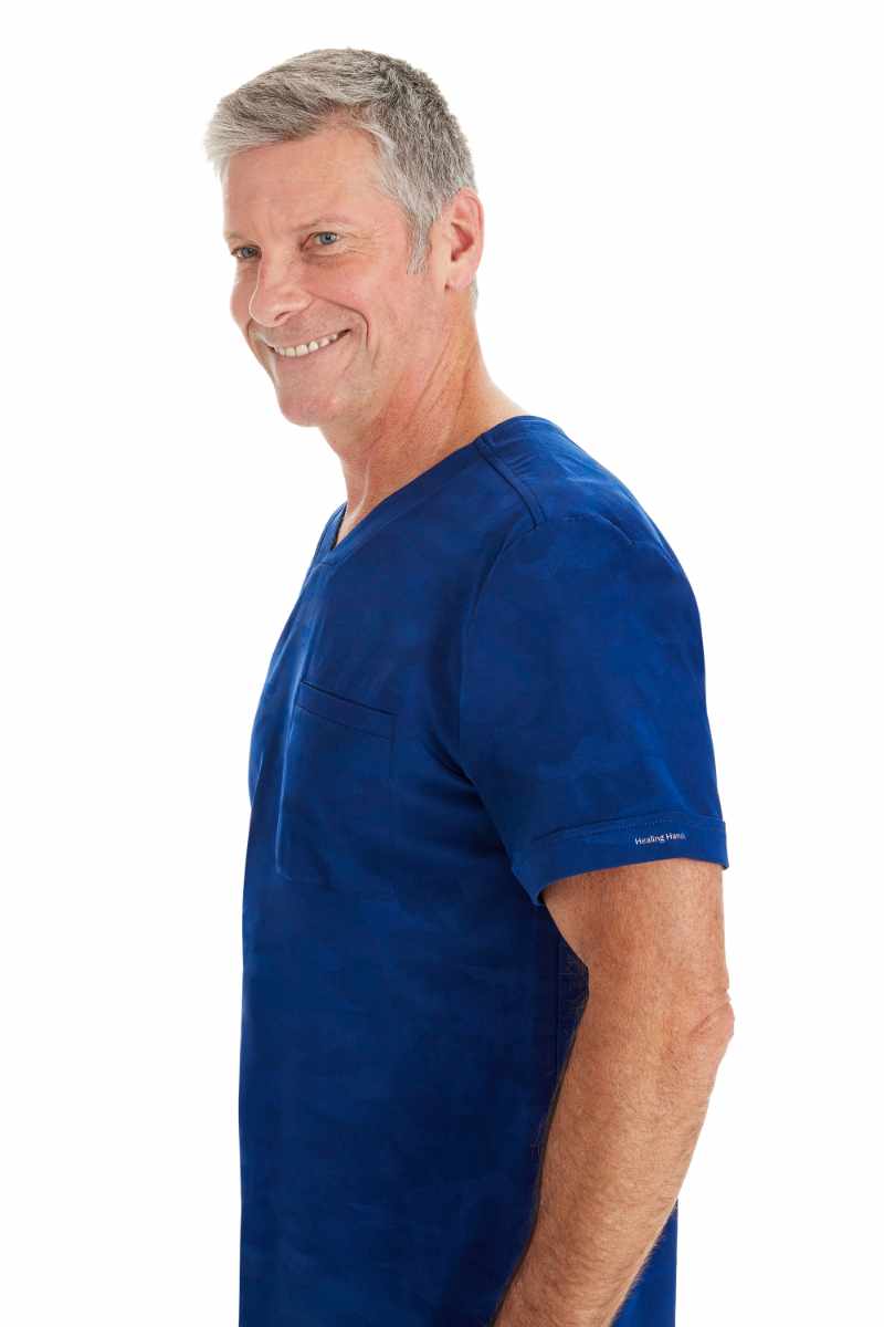 A male physician wearing a Purple Label by Healing Hands Men's Jack Camo Top in "Navy" size 2XL featuring folded cuffs at the sleeves.