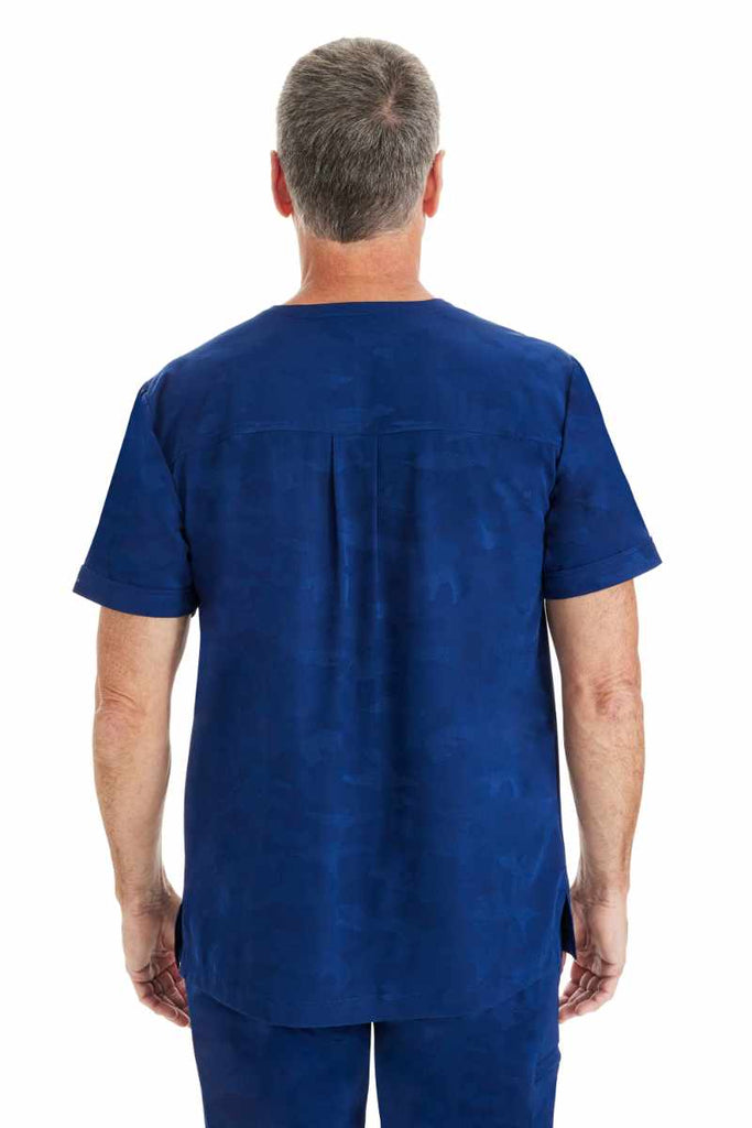 An image of a male Home Health Aide wearing a Purple Label by Healing Hands Men's Jack Camo Scrub Top in "Navy" size Large featuring a center back yoke with box pleat detail.