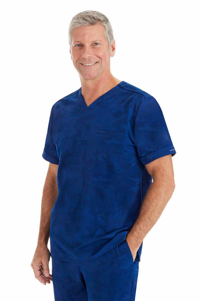 A male Medical Assistant wearing a Purple Label by Healing Hands Men's Jack Camo Scrub Top in "Navy" size XL featuring a modern fit.