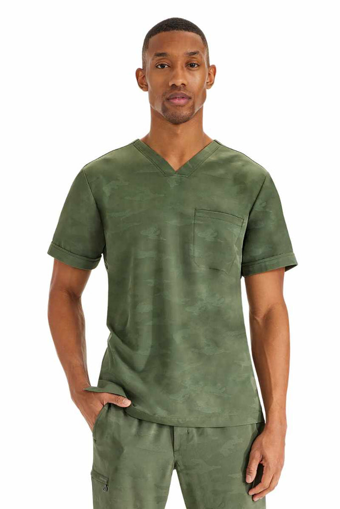 A young male Pharmacy Technician wearing a Purple Label by Healing Hands Men's Jack Camo Scrub Top in "Olive" size XL featuring a modern fit.