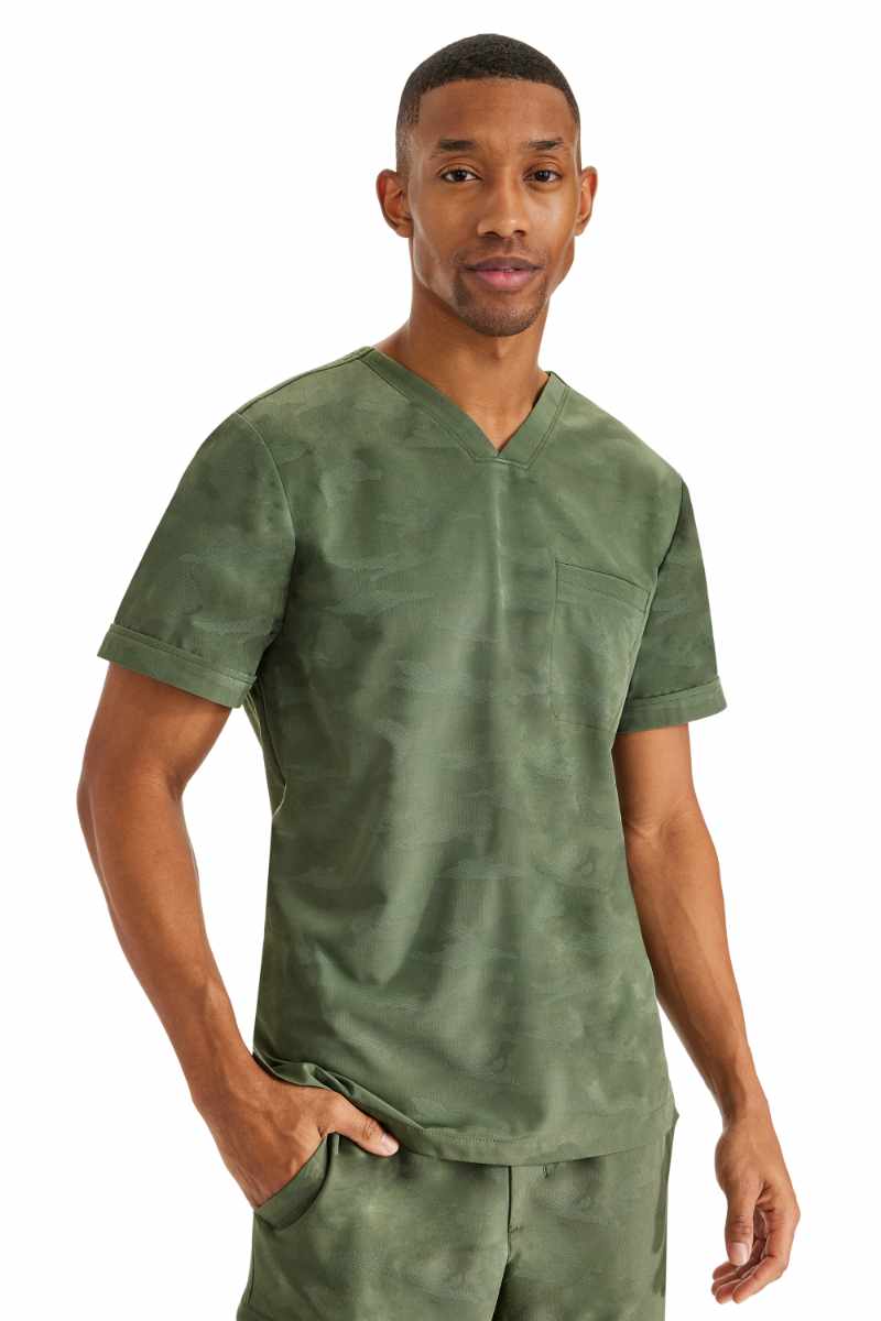 A young male Diagnostic Medical Sonographer wearing a Purple Label by Healing Hands Men's Jack Camo Scrub Top in "Olive" size medium featuring 1 chest pocket on the wearer's left side.