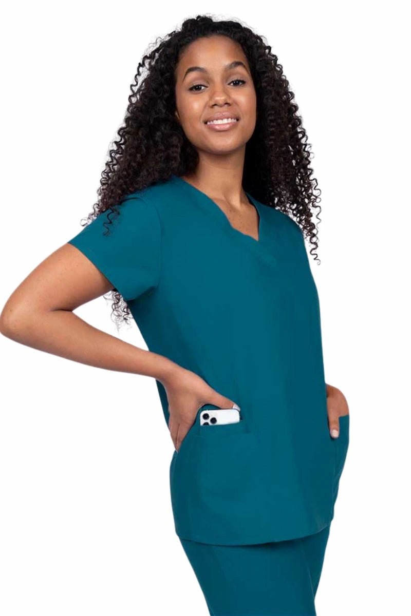 Young nurse wearing a Luv Scrubs by MedWorks Women's V-neck Scrub Top in Caribbean with featuring short sleeves, and a total of 3 pockets.