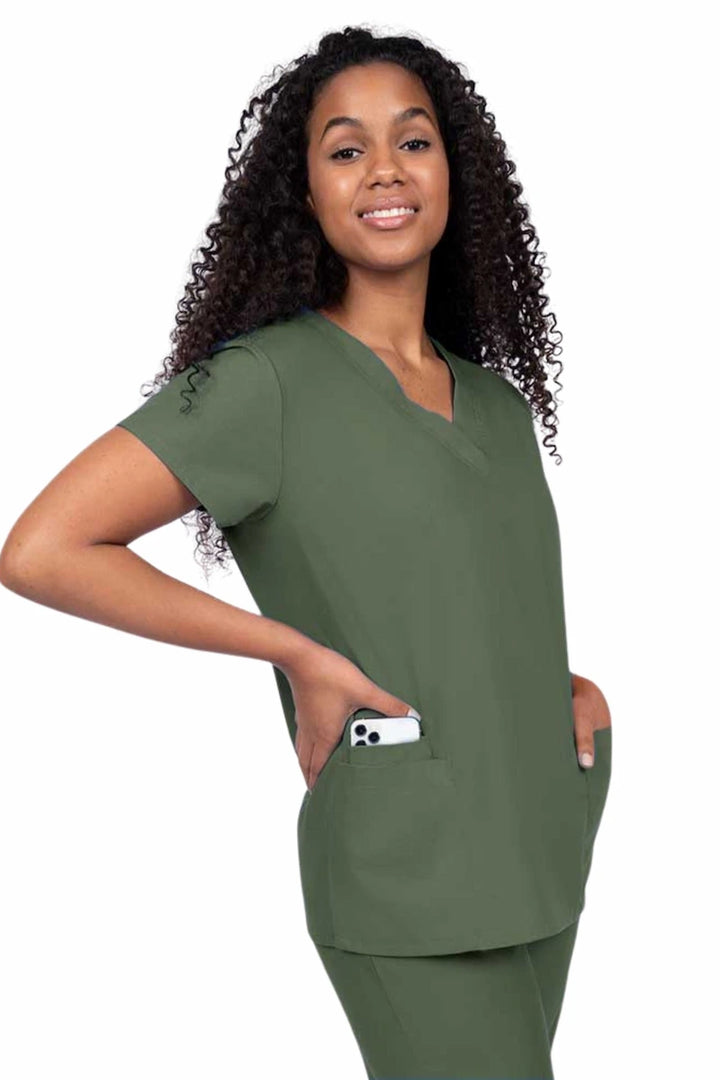 Young nurse wearing a Luv Scrubs by MedWorks Women's V-neck Scrub Top in olive with featuring short sleeves, and a total of 3 pockets.