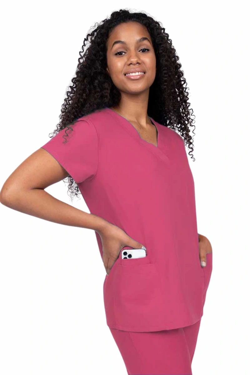 Young nurse wearing a Luv Scrubs by MedWorks Women's V-neck Scrub Top in shocking pink with featuring short sleeves, and a total of 3 pockets.