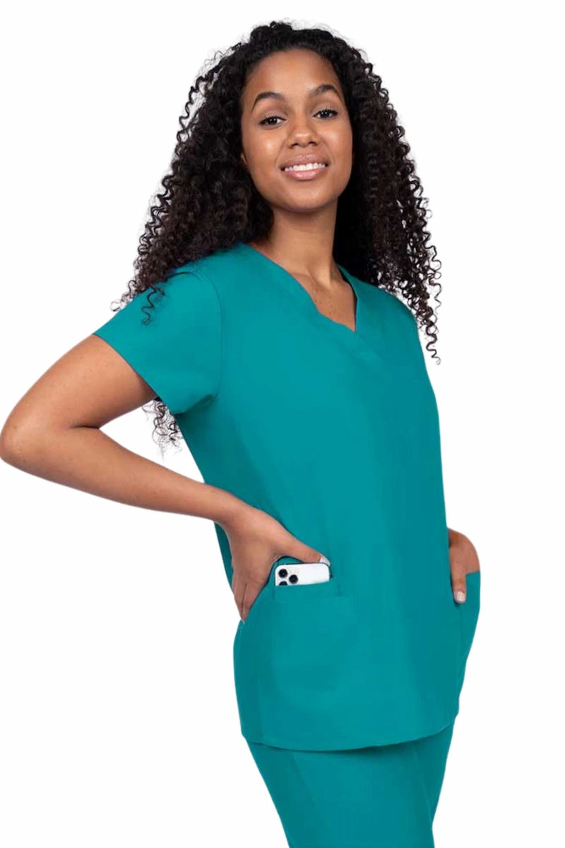 Young nurse wearing a Luv Scrubs by MedWorks Women's V-neck Scrub Top in teal with featuring short sleeves, and a total of 3 pockets.