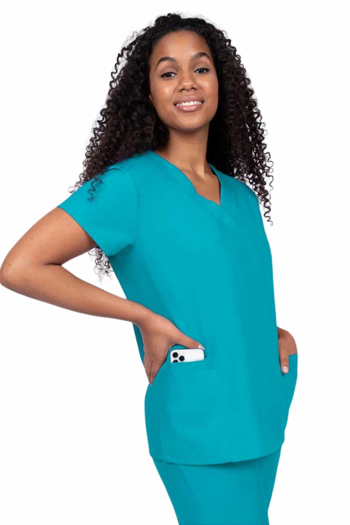 A young female Dental Assistant wearing a Luv Scrubs by MedWorks Women's V-neck Scrub Top in Turquoise featuring two front patch pockets.