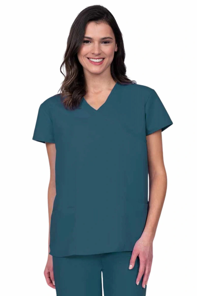 Young woman wearing a Luv Scrubs by MedWorks Women's Mock Wrap Scrub Top in Caribbean featuring a Y-neckline and side slits for additional range of motion.