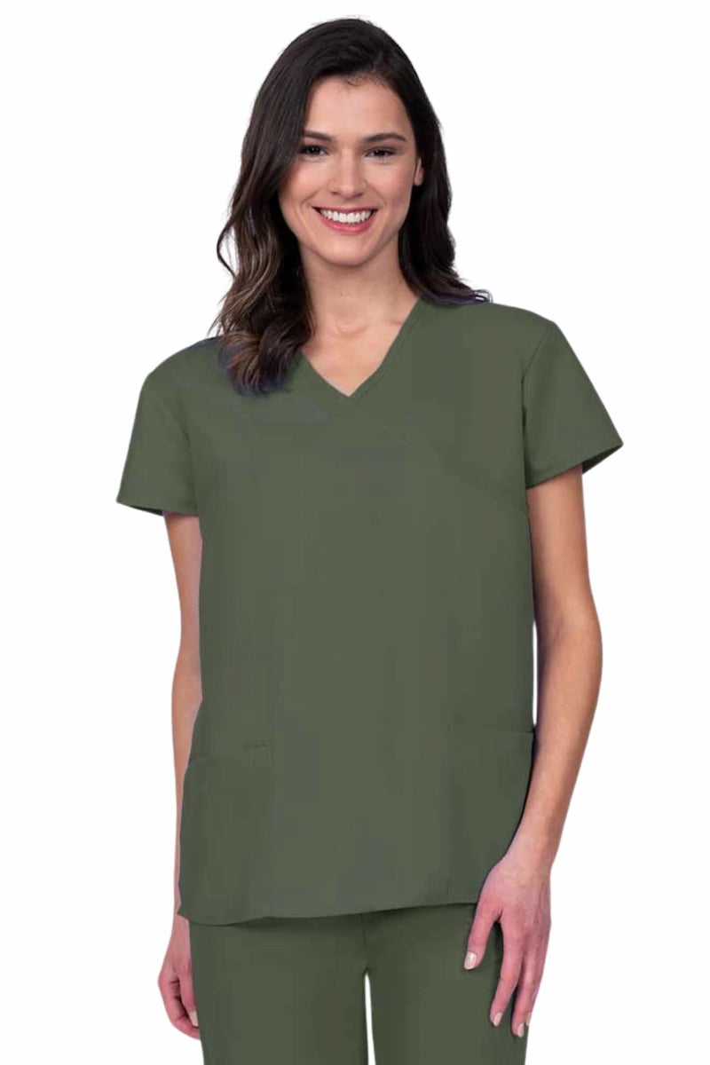 Young woman wearing a Luv Scrubs by MedWorks Women's Mock Wrap Scrub Top in olive featuring a Y-neckline and side slits for additional range of motion.