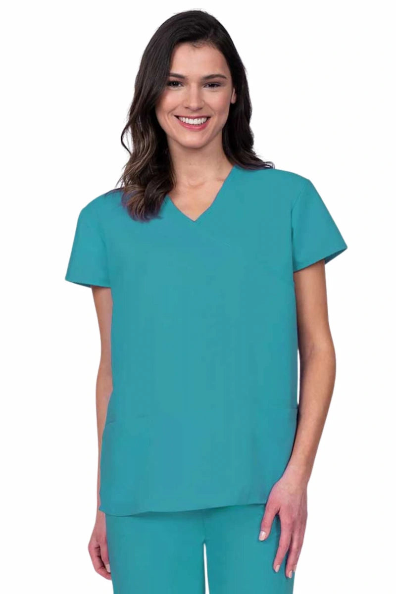 Young woman wearing a Luv Scrubs by MedWorks Women's Mock Wrap Scrub Top in turquoise featuring a Y-neckline and side slits for additional range of motion.