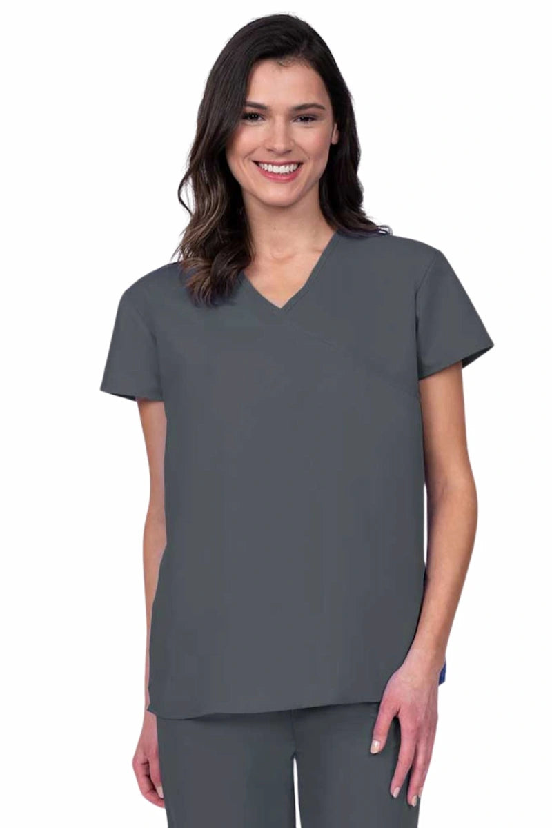 Nurse wearing a Luv Scrubs by MedWorks Women's Pocketless Mock Wrap Scrub Top in pewter featuring a Y-neckline & side slits for additional mobility.