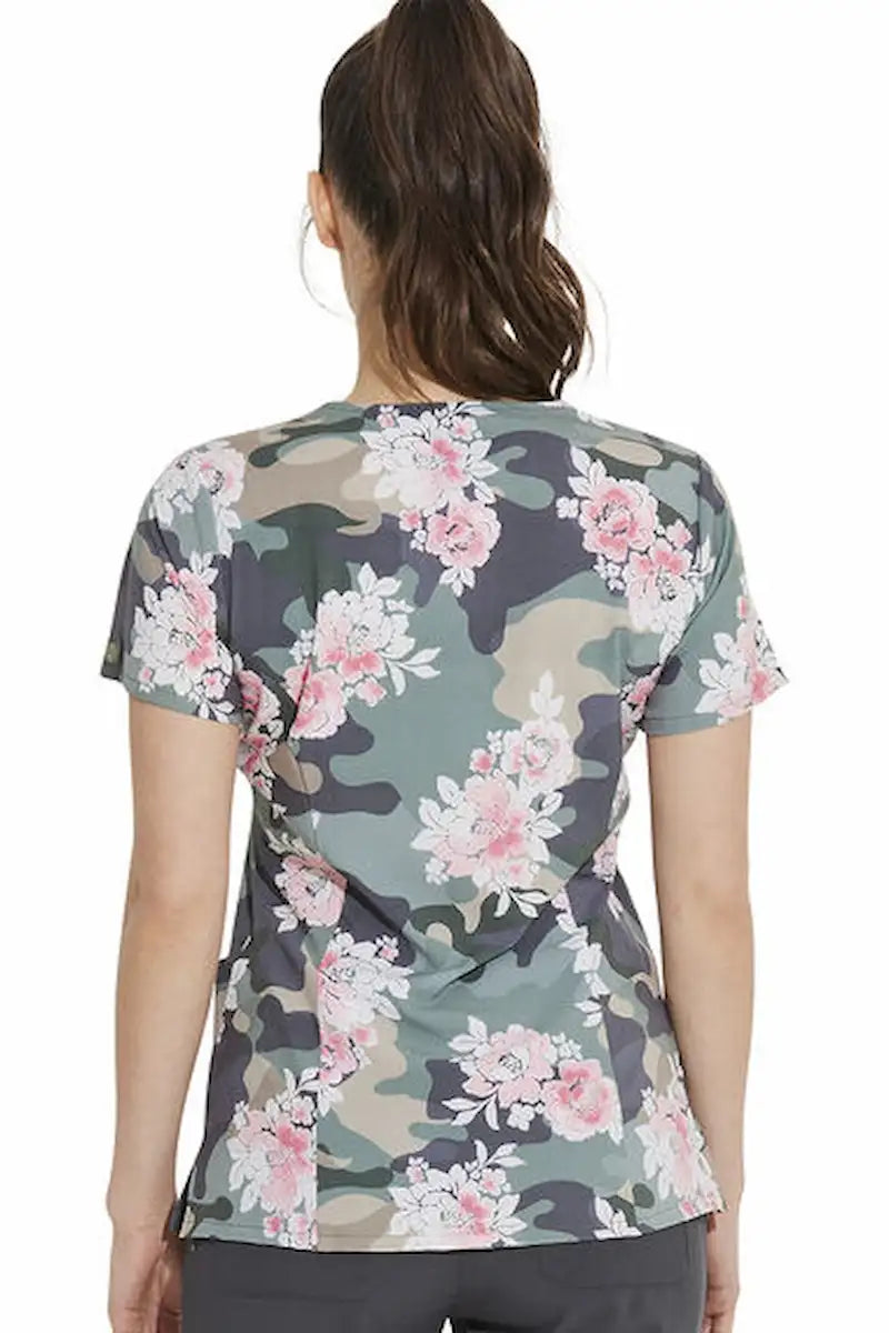 A young female Psychiatric Nurse wearing a Dickies Women's V-Neck Printed Scrub Top in "Camo's Abloom" featuring a center back length of 27.75".