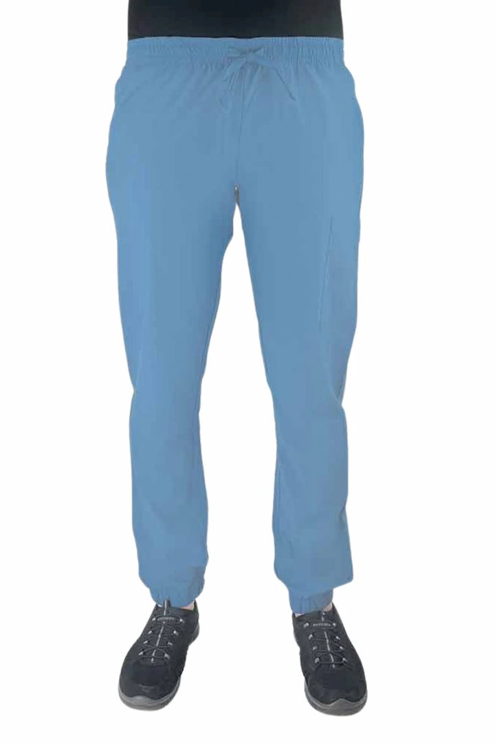 Young female healthcare worker wearing a Luv Scrubs by MedWorks Women's Scrub Jogger in ceil with 2 front slash pockets & 1 cargo pocket on wearer's left leg.