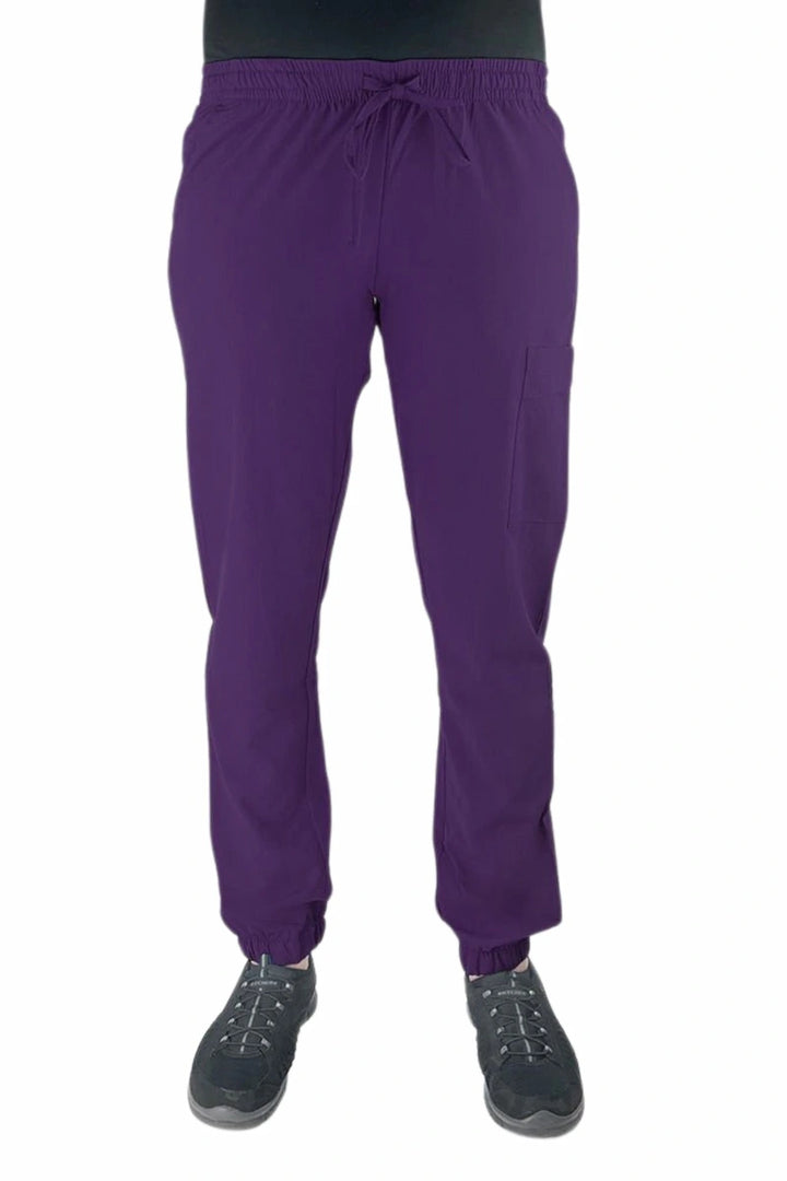 Young female healthcare worker wearing a Luv Scrubs by MedWorks Women's Scrub Jogger in eggplant with 2 front slash pockets & 1 cargo pocket on wearer's left leg.