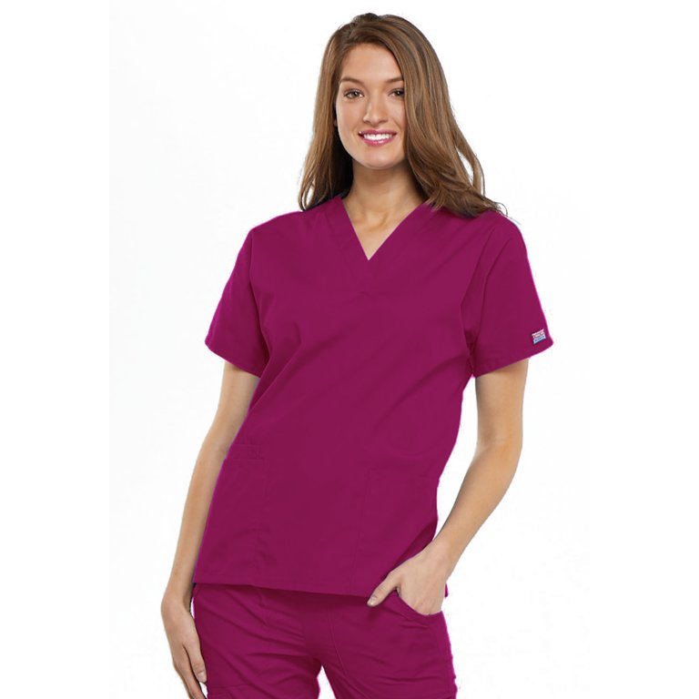 A young female nursing assistant wearing a Cherokee Workwear Originals Women's Multi-pocketed V-neck Scrub Top in Raspberry featuring short sleeves.