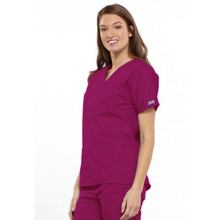 A young female Home Health Aide wearing a Cherokee Workwear Originals Women's Multi-pocketed V-neck Scrub Top in Raspberry featuring a center back length of 26.5".