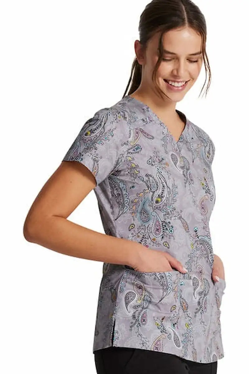 A young female psychiatric nurse wearing a Dickies Women's V-Neck Print Scrub Top in Denim Paisley featuring two spacious front patch pockets.