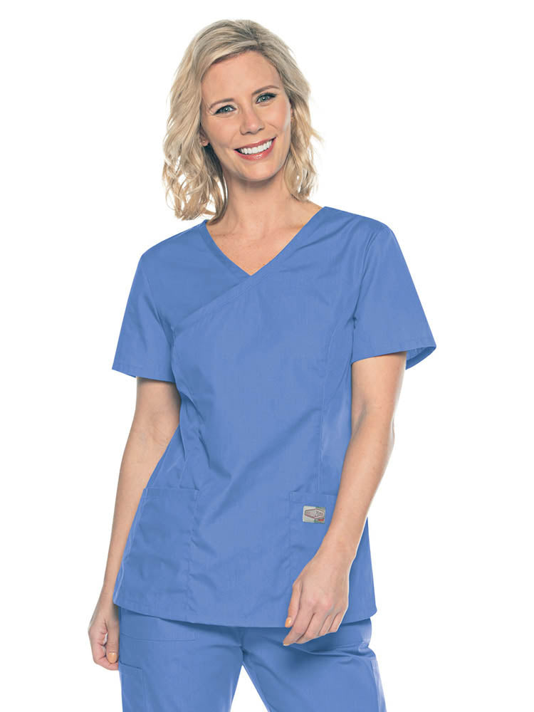 A young female Medical Assistant wearing a Landau ScrubZone Women's Mock Wrap Top in Ceil size Small featuring a modern tailored fit.