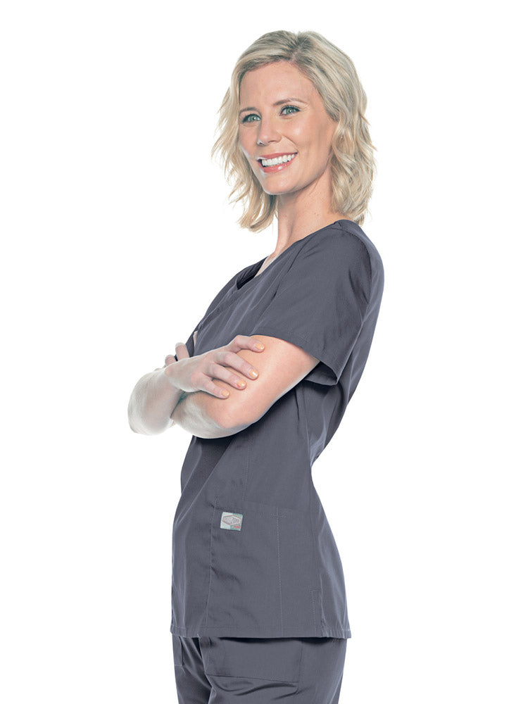 A young female Nursing Assistant wearing a Landau Women's Mock Wrap Scrub Top in Steel Grey size Medium featuring short sleeves.