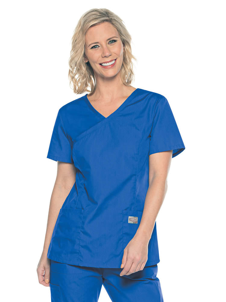 A young female Medical Assistant wearing a Landau ScrubZone Women's Mock Wrap Top in Royal size Small featuring a modern tailored fit.