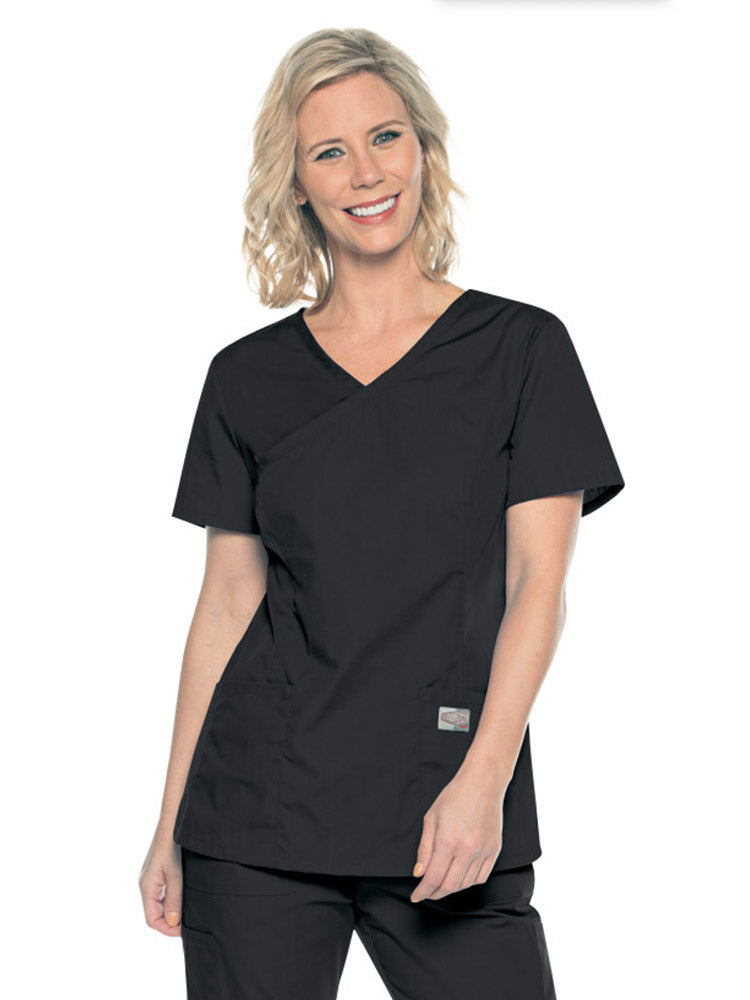 A young female Medical Assistant wearing a Landau ScrubZone Women's Mock Wrap Top in Black size Small featuring a modern tailored fit.
