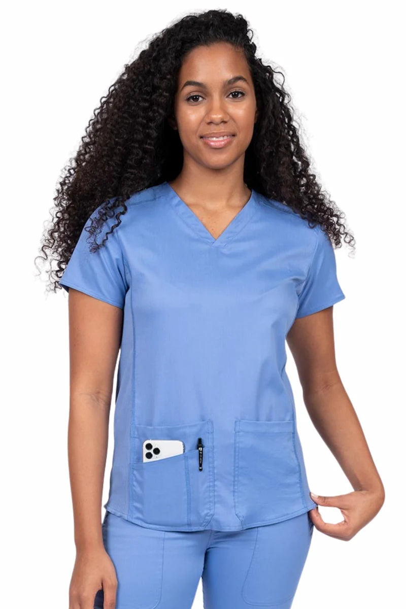 Nurse wearing an Epic by MedWorks Women's Blessed Scrub Top in ceil with a V-neckline & short sleeves.