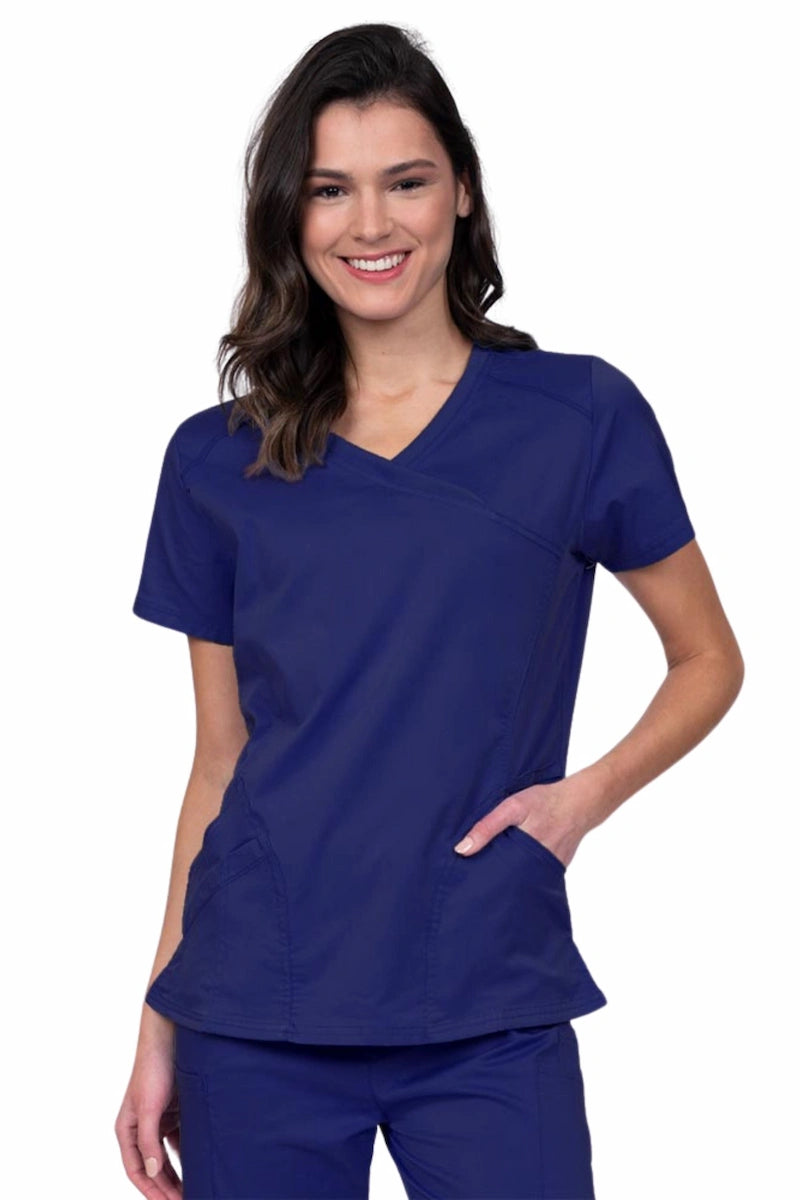 Young RN wearing an Epic by MedWorks Women's Knit Collar Mock Wrap Scrub Top in navy featuring a Y-neckline with short sleeves.