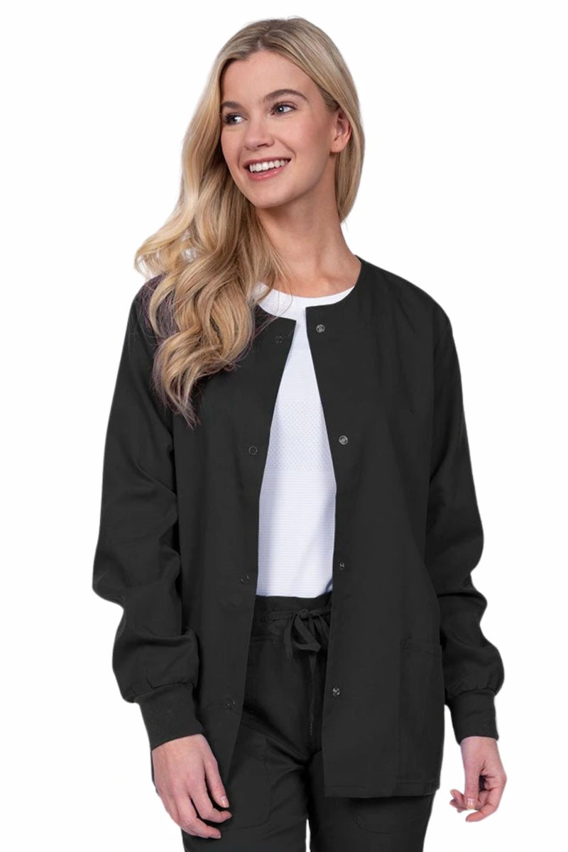 Young female healthcare worker wearing an Epic by MedWorks Women's Snap Front Scrub Jacket in black with two front patch pockets.