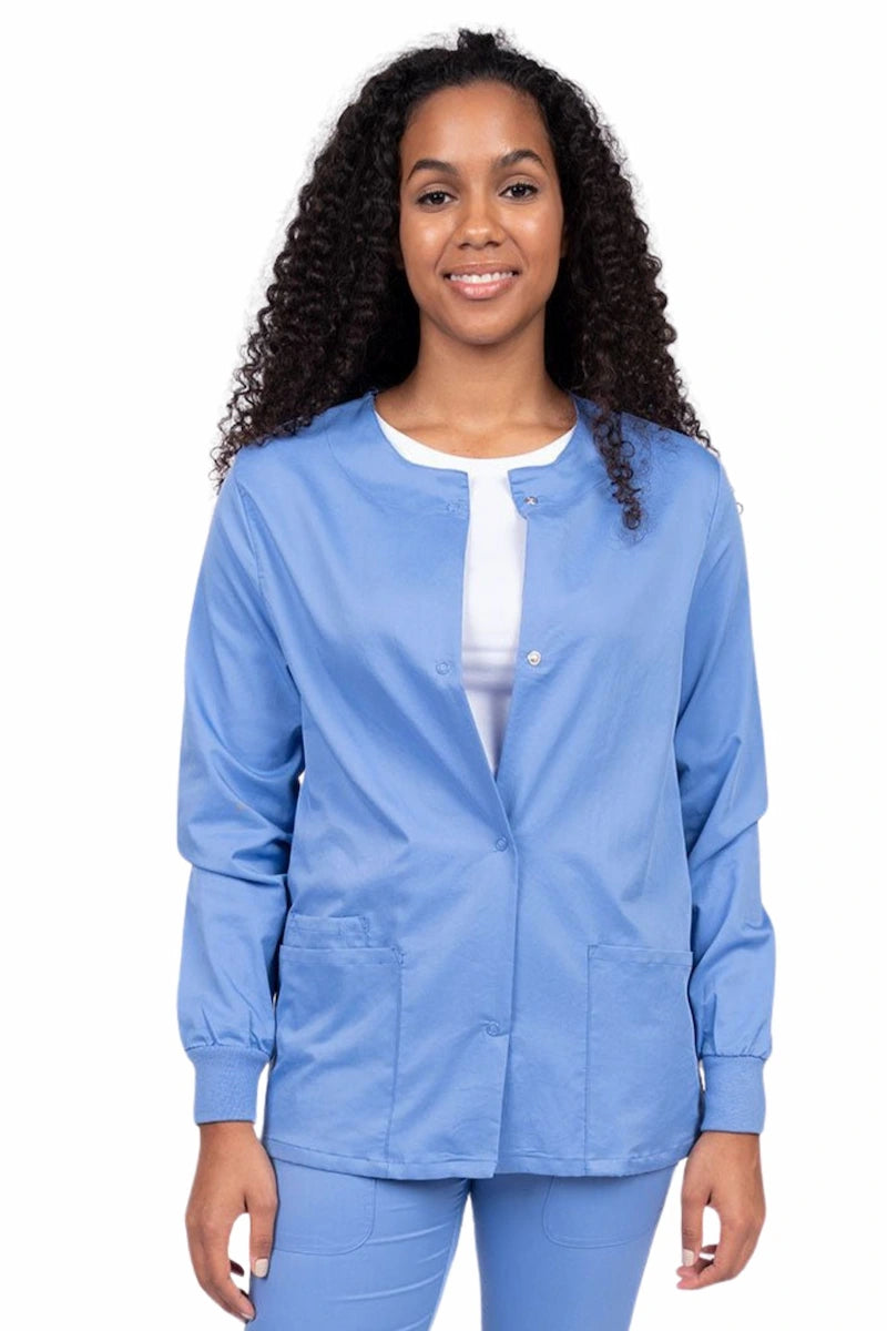 Young female healthcare worker wearing an Epic by MedWorks Women's Snap Front Scrub Jacket in ceil with two front patch pockets.