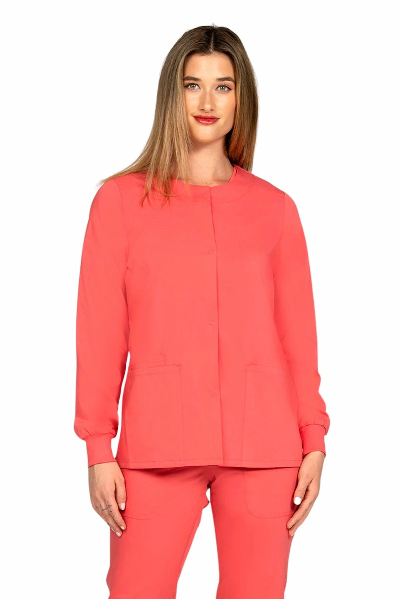 A young female healthcare worker wearing an Epic by MedWorks Women's Snap Front Scrub Jacket in Coral featuring snap front closure.