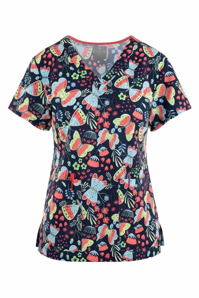 A young female Psychiatric Nurse showcasing the front of the Med Couture Women's Valerie Print Scrub Top in Butterfly Friends size large featuring a classic V-neckline and two front patch pockets.