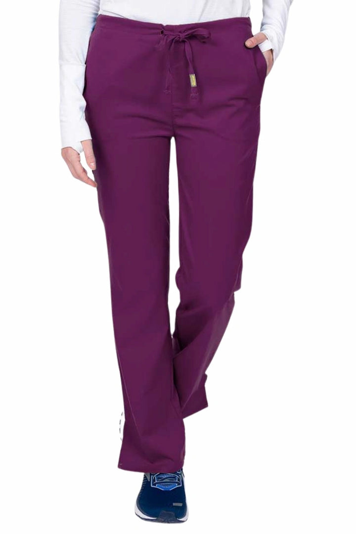 Young nurse wearing an Epic by MedWorks Women's Drawstring Flare Leg Scrub Pant in eggplant with unique stretch fabric made of 77% Polyester, 21% Viscose, 2% Spandex.