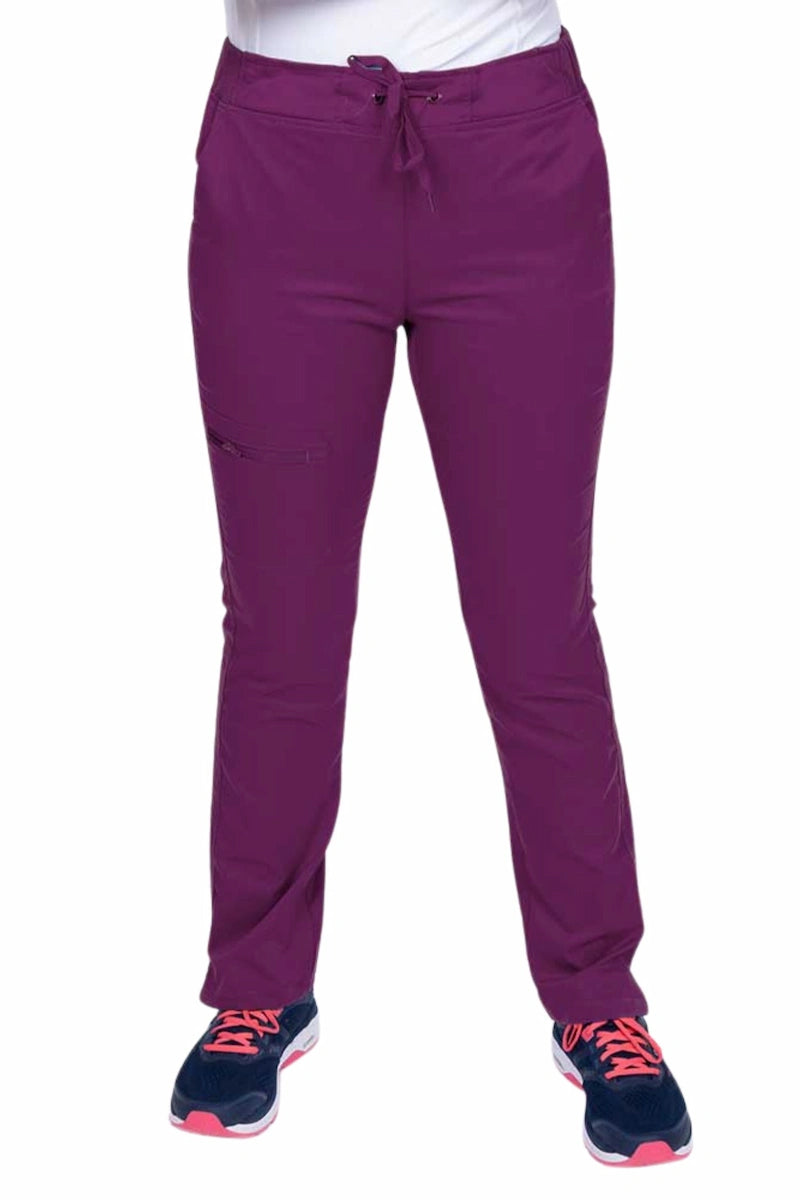 Young healthcare worker wearing an Epic by MedWorks Women's Blessed Skinny Yoga Scrub Pant in eggplant featuring side slits for additional range of motion.