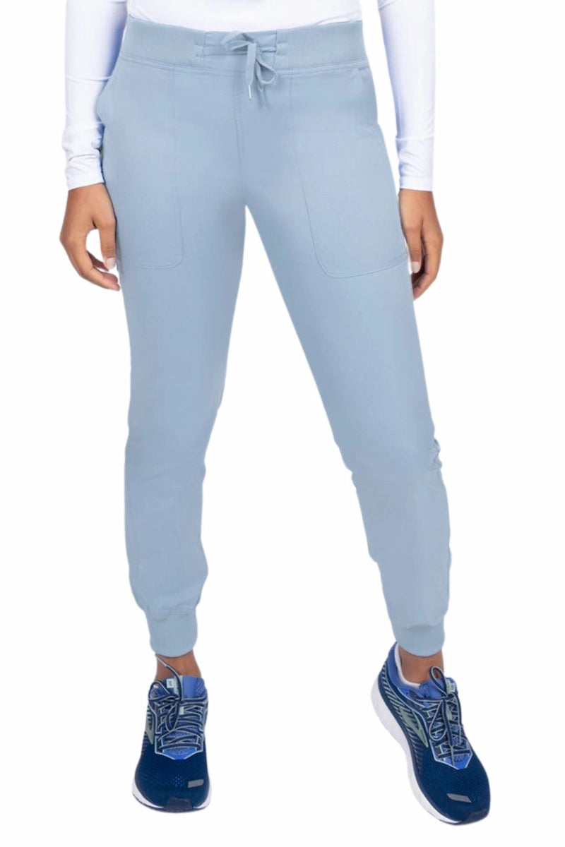 A young female Phlebotomist wearing an Epic by MedWorks Women's Yoga Jogger Scrub Pant in Blue Fog size 3XL featuring a contemporary fit.