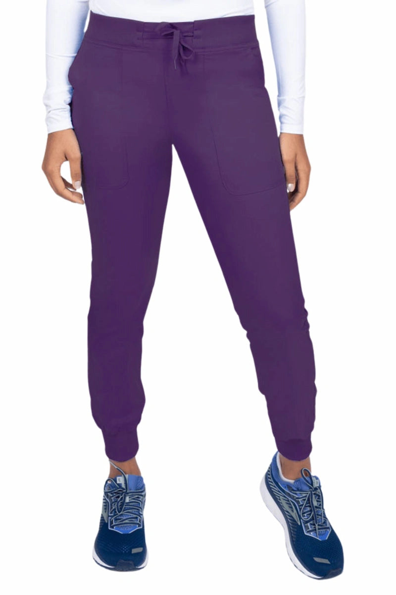 A young female Phlebotomist wearing an Epic by MedWorks Women's Yoga Jogger Scrub Pant in Eggplant size 3XL featuring a contemporary fit.