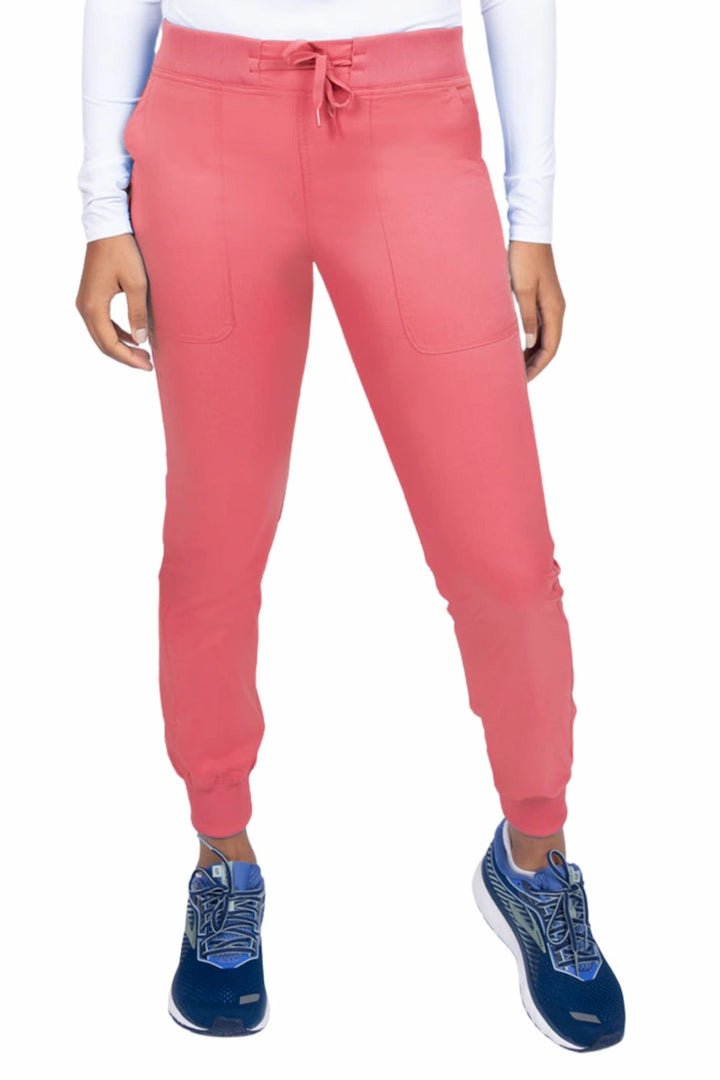 A young female Phlebotomist wearing an Epic by MedWorks Women's Yoga Jogger Scrub Pant in Coral size 3XL featuring a contemporary fit.