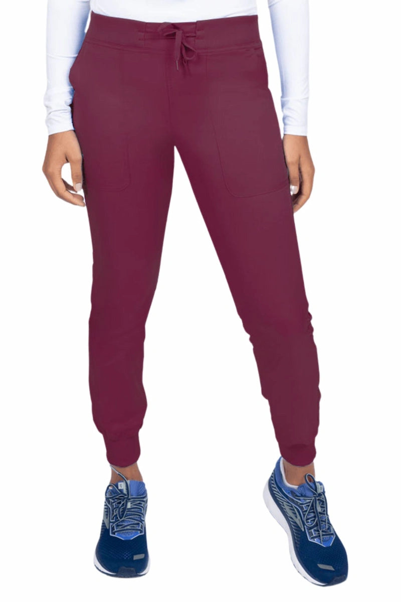 A young female Phlebotomist wearing an Epic by MedWorks Women's Yoga Jogger Scrub Pant in Wine size 3XL featuring a contemporary fit.