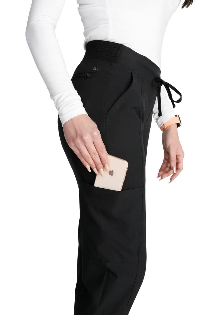 A close look at the secure cargo pocket with a security ring clasp and bungee cord on the Allura Women's High Waist Gusset Jogger in Black size Small Petite.