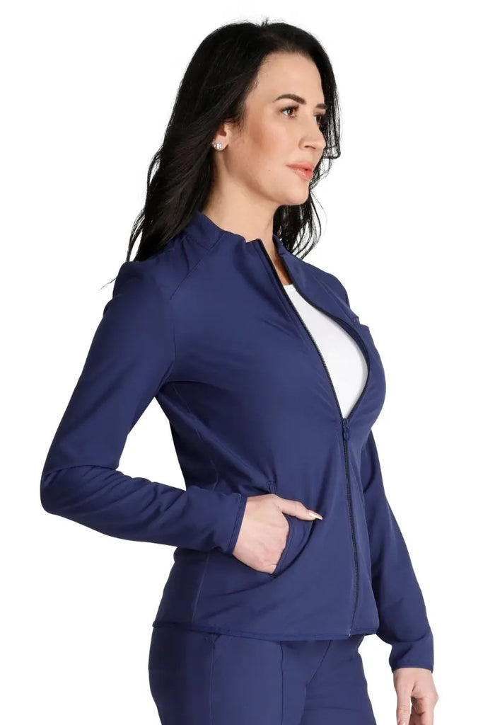 A young female Registered Nurse wearing an Allura Women's Zip Front Scrub Jacket in Navy Blue size XL featuring a contemporary fit.