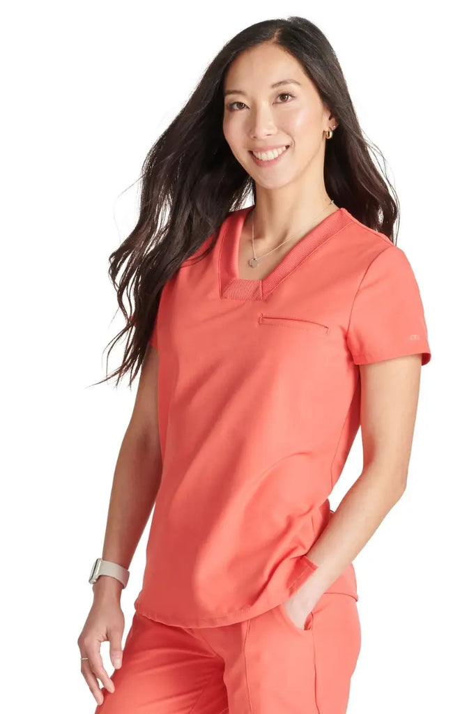 A female Gynecologist wearing an Allura Women's Mitered Scrub Top in Cayenne featuring side vents.