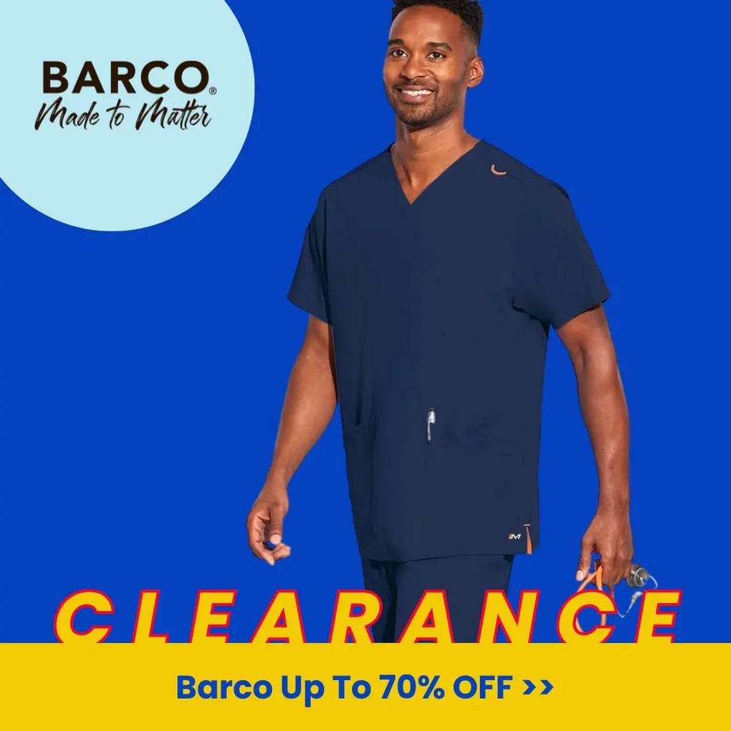 A young male nurse practitioner wearing Navy Blue scrubs on a royal blue background. Barco Scrubs are on sale at Scrub Pro for up to 70% off. 