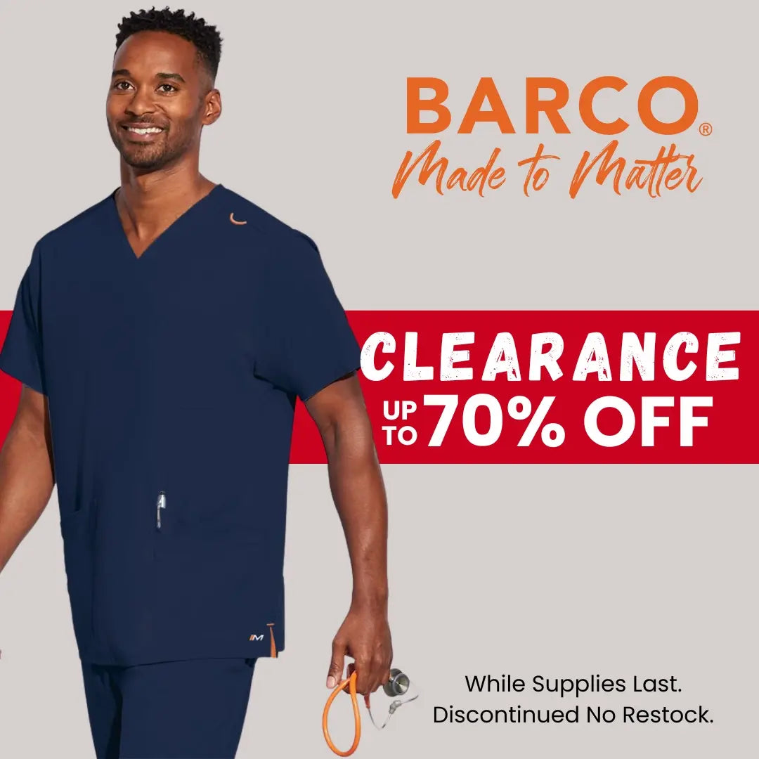 A young male nurse practitioner wearing Barco Scrubs from Scrub Pro's Clearance section on a light grey background.