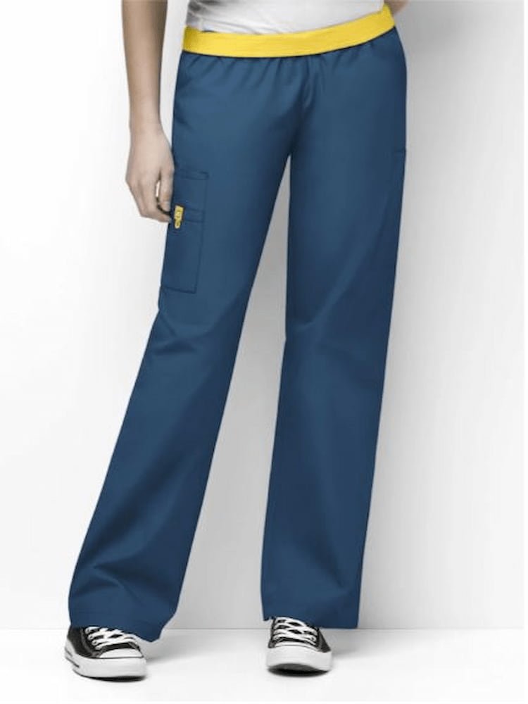 A young female Clinical Lab Technologist wearing a pair of WonderWink Origins Women's Elastic Waist Cargo Scrub Pants in Caribbean size Small featuring one WonderWink signature triple pocket with hidden mesh cell phone pocket.