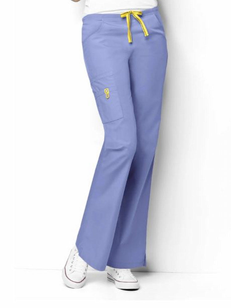 A middle aged female Physician's Assistant wearing a pair of the WonderWink Origins Women's Romeo Cargo Scrub Pants in Ceil Blue size XS featuring a total of 6 pockets.