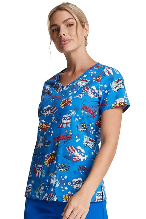 A young female RN wearing a Women's V-Neck Print Top from Dickies Medical in "Super Smile" featuring 2 double patch pockets.