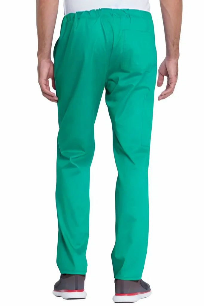 A young male Surgeon wearing a pair of the Dickies Industrial Unisex Mid-Rise scrub Pants in Surgical Green featuring a straight leg design offers unrestricted movement all day long.