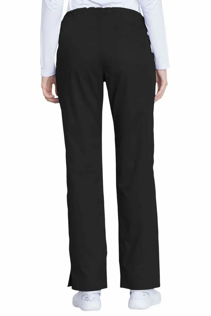A young female CNA wearing a pair of the Dickies Industrial Women's Drawstring Scrub Pants in Black size Large Tall featuring a straight leg design with side slits for additional mobility throughout the day.