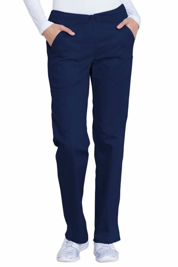 A young female LPN wearing a pair of the Dickies Industrial Women's Drawstring Scrub Pants in Navy Blue size Large featuring a modern classic fit that  offers a professional look while allowing for ease of movement.